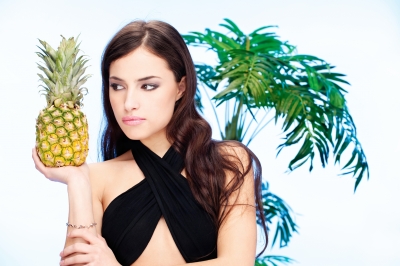 žena s ananásom v ruke